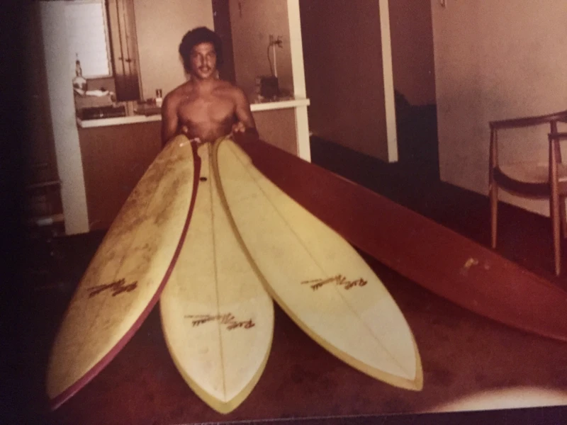 Vintage photograph of Trinko holding surfboards